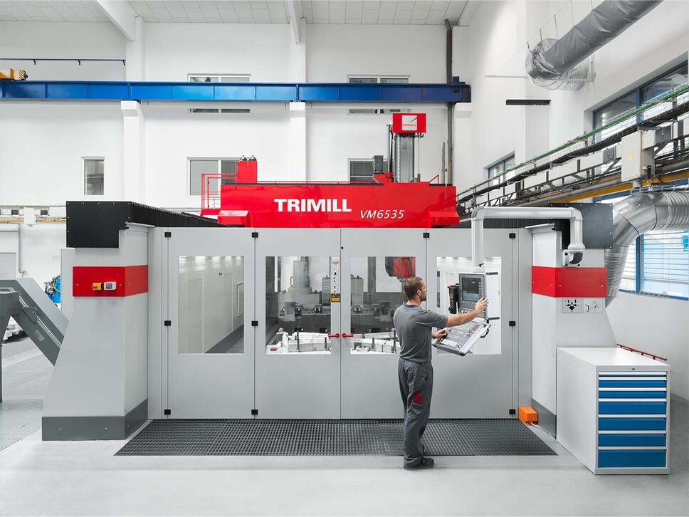 großes Bearbeitungszentrum der Marke Trimill VM6535 wird von einem Zerspanungstechniker auf der Steuerungskonsole programmiert