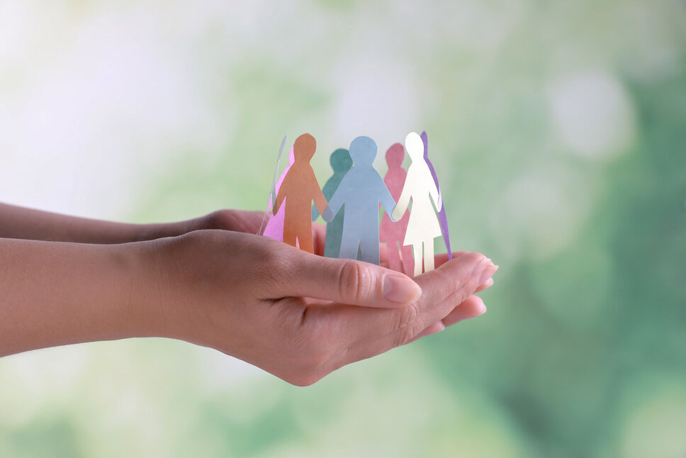 Nahaufnahme von Händen, die menschliche Papierfiguren halten, vor einem verschwommenen Hintergrund. Dieses Bild veranschaulicht das Konzept von Diversität und Inklusion. In der Geschäftsethik von weba Werkzeugbau symbolisiert dieses Bild die Richtlinie zur Warhung der Menschenrechte und Einhaltung arbeitsrechtlicher Vorschriften.