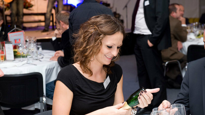 weba Werkzeugbau - Jubiläumsfeier VIP-Abend Jasmina Tricic bei der 30-Jährigen-Jubiläumsfeier, erfreut durch den Trick eines Magiers, umgeben von feierlichen Gästen und festlicher Dekoration.