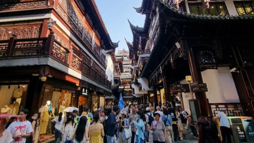 Belebte Gasse mit traditioneller chinesischer Architektur und vielen Passanten in Shanghai – eine Momentaufnahme aus Jan Wengryns Zeit in China.