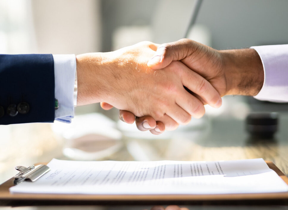Handschlag von zwei Geschäftsleuten über einen Vertrag, dass die Partnerschaft von weba Werkzeugbau und Meprotec im Bereich der Prozesstechnik für das Presshärten symbolisiert