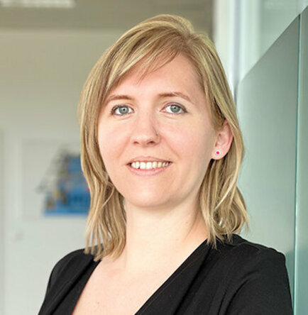 Porträt von Tanja Burghuber, Personalmanagerin bei weba Werkzeugbau, entspannt an einer Milchglaswand in Dietach lehnend, mit einem professionellen und freundlichen Ausdruck, betont durch die weiche Beleuchtung und den verschwommenen Hintergrund. Das Foto wird im Kontaktbereich der Stellenangebote in Steyr von weba Werkzeugbau verwendet.