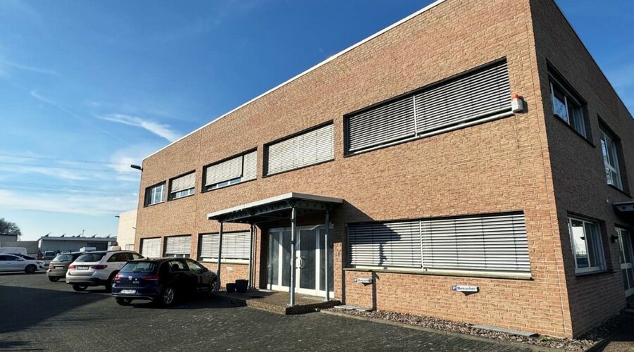 Firemní budova společnosti weba Deutschland GmbH, odborník na stavbu prototypů, za slunečného počasí s parkovišti a moderní architekturou.