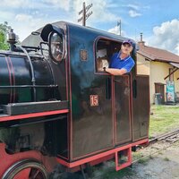 František Krumpolec stands in the cab of a historic steam locomotive, smiling as he looks out of the window.