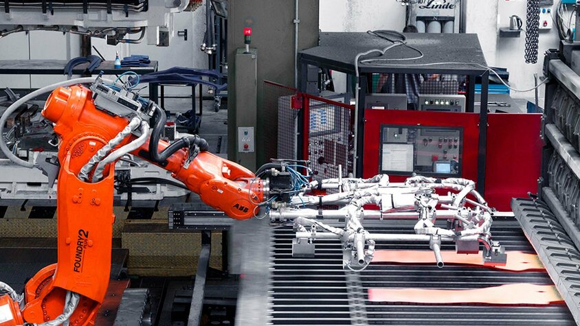 weba Werkzeugbau - Platinentransfer in der Warmumformung Roboter-Arm entnimmt zwei glühende Formplatinen für den Transfer in die Warmumformpresse