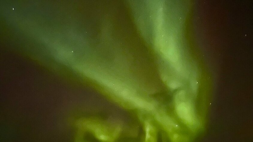 Polarlichter über Alaska Magische grüne Polarlichter tanzen über den dunklen Himmel in einer einsamen Winterlandschaft.