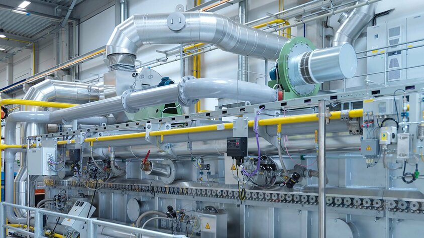weba Werkzeugbau - Austenitisierung im Rollenherdofen Eine Aufnahme zeigt einen Abschnitt eines Rollenherdofens, der speziell für die Austentisierung von Formplatinen vor ihrer anschließenden Umformung in einem Presshärtewerkzeug konzipiert ist.