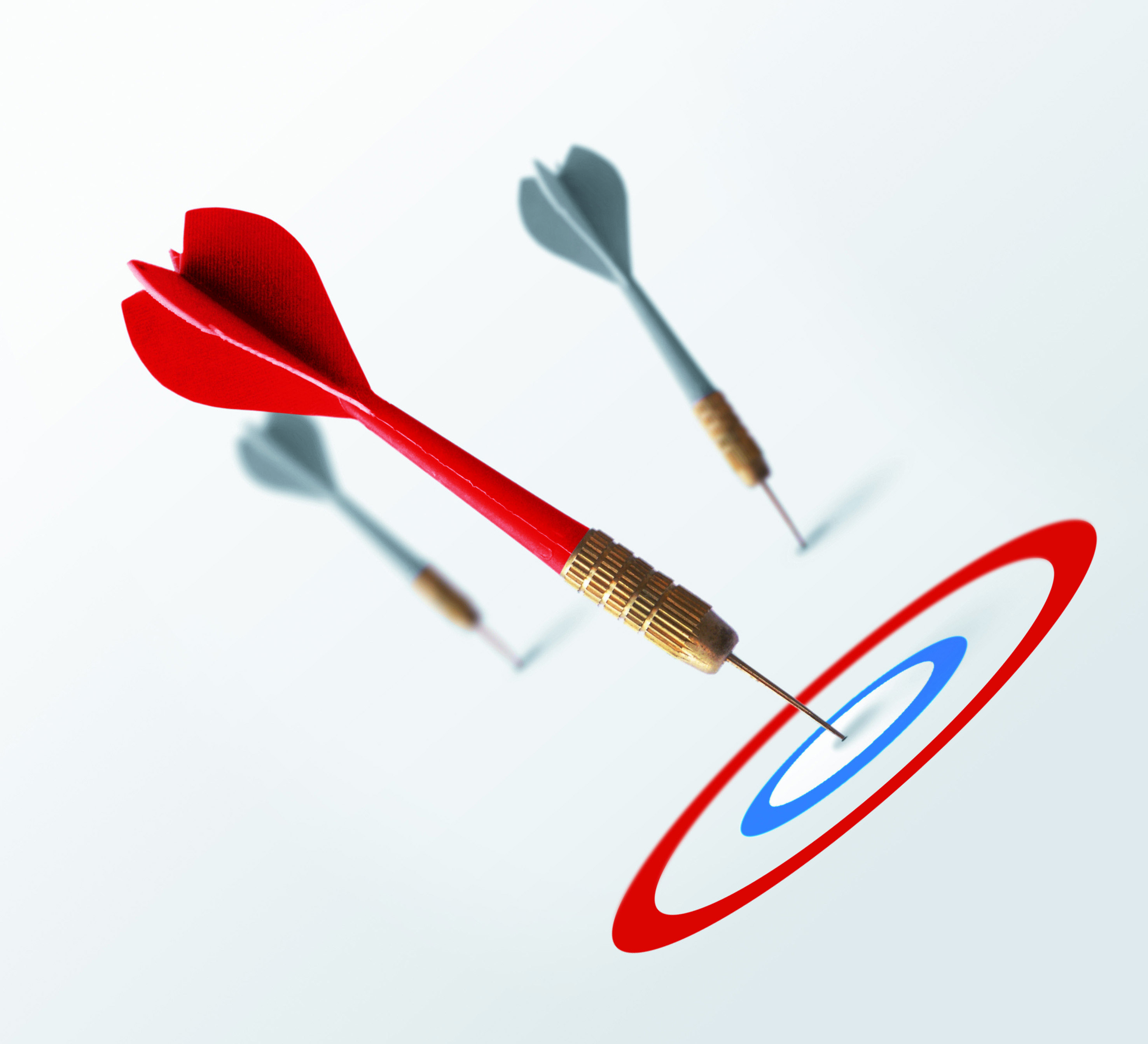 Roter Dartpfeil trifft genau ins Bullseye, zwei graue Pfeile verfehlen das Ziel – Symbol für klare Zielsetzung mit der SMART-Methode.